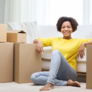 smiling woman sitting next to cardboard boxes | 3GuysMoving.com 3 Guys Moving