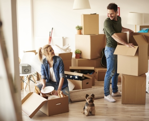 young couple packing moving boxes | 3GuysMoving.com