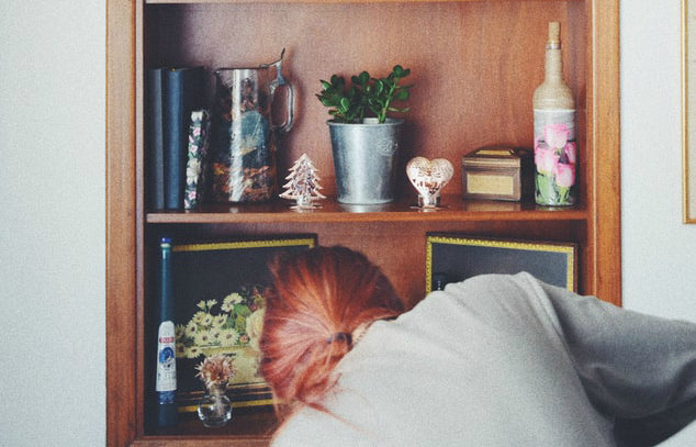 Woman Cleaning Book Shelf | 3GuysMoving.com